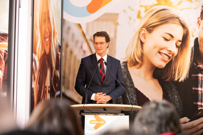 NRW-Verkehrsminister Hendrik Wüst steht an einem Rednerpult vor einem Plakat der App.