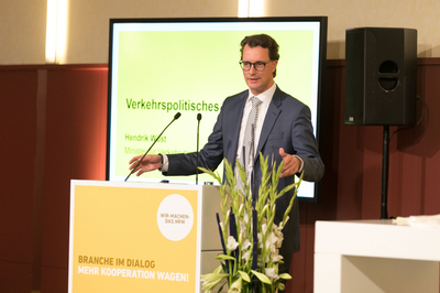 NRW-Verkehrsminister Hendrik Wüst steht bei der Auftaktveranstaltung zur Agenda Bahnen NRW hinter einem Pult und hält eine Rede.