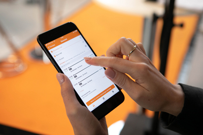 Nahaufnahme eines Handybildschirms, auf dem die mobil.nrw App geöffnet ist. Eine Hand tippt gerade auf dem Bildschirm.