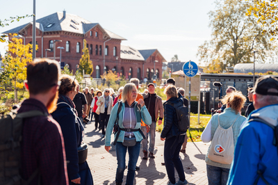 Eine große Menschengruppe startet vor dem NRW-Wanderbahnhof Dorsten zur Wanderung.